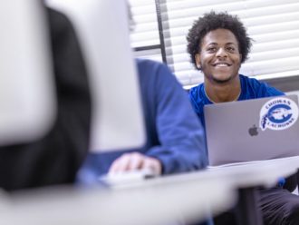 student in class with macbook