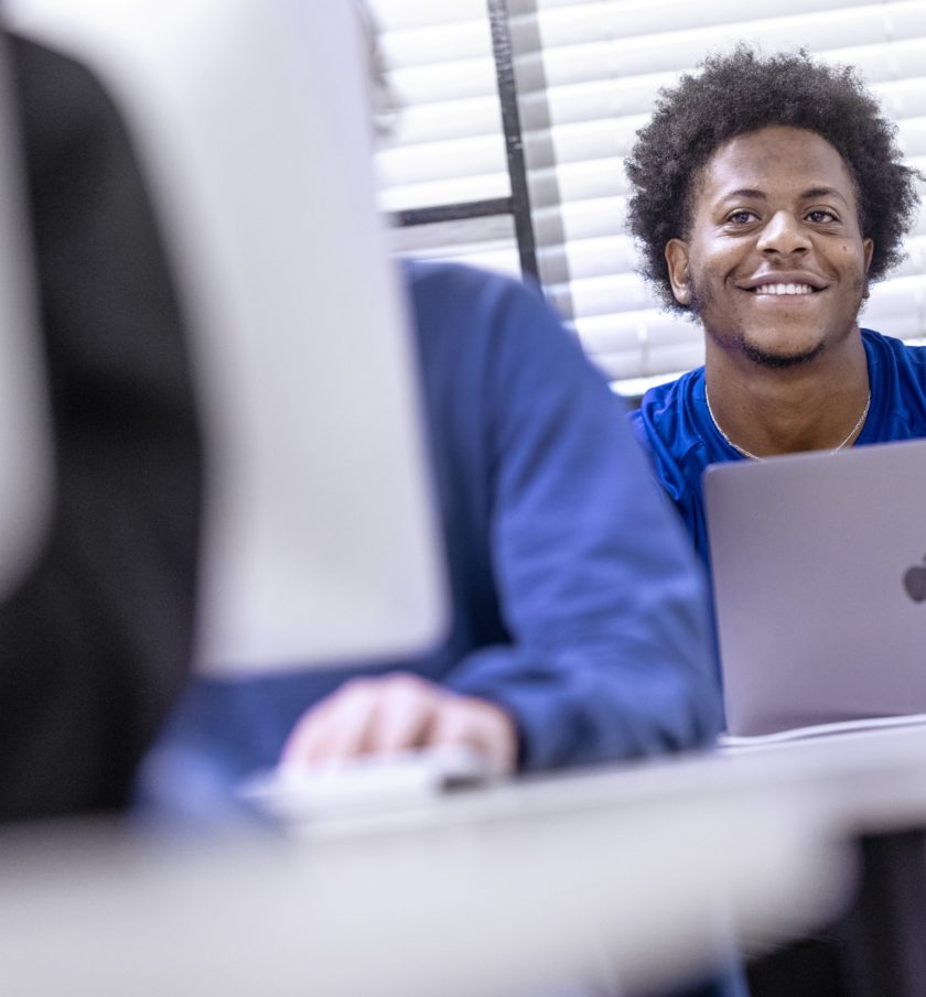 student in class with macbook