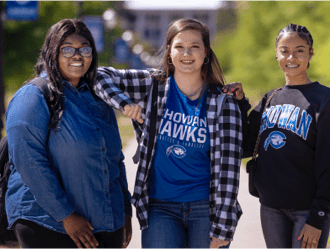 Three female students wearing Chowan University blue, standing in Squirrel Park
