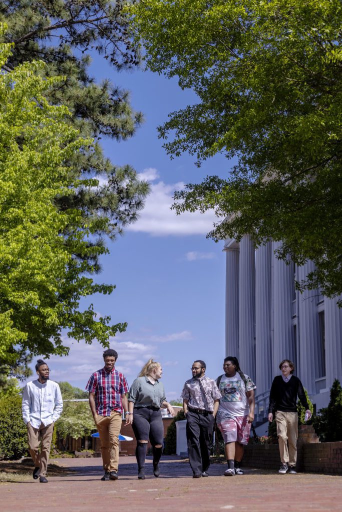 A group of students walking in front of the Columns Building