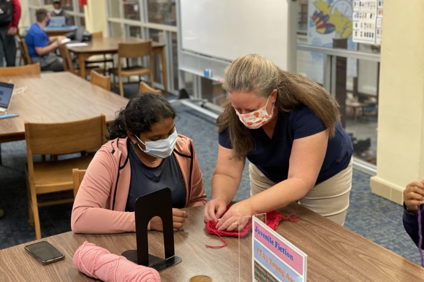 University Librarian demonstrating crochet techniques to student