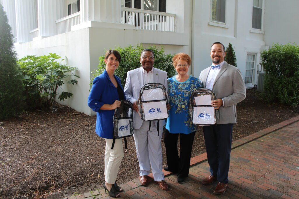 Dr. Shelley Greene, Vice President of Enrollment and Advancement, Dr. Jesse J. Pratt, Superintendent of Hertford Public County Schools, Dr. Rosemary Thomas, Chowan University President, and Taylor Furlough, Interim Director of Admissions, stand together with the clear backpacks donated to HCPS.