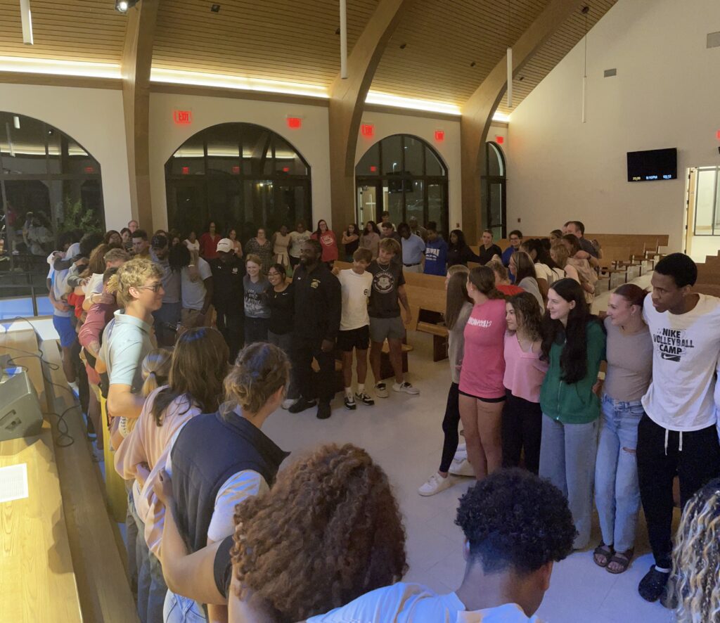 Students circle around together to pray.