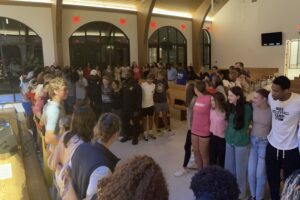 Students circle around together to pray.